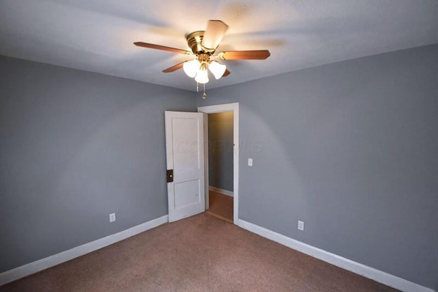 spare room featuring carpet, ceiling fan, and baseboards