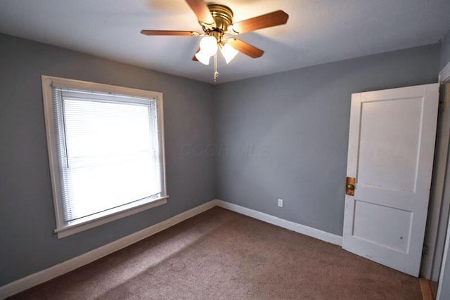 spare room featuring carpet flooring, a ceiling fan, and baseboards