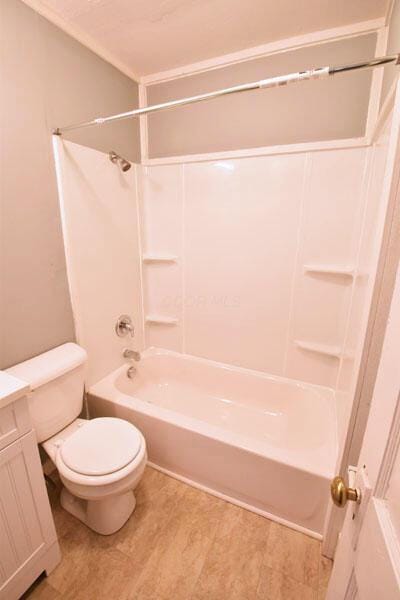 full bath with tub / shower combination, vanity, toilet, and wood finished floors