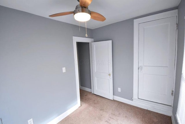 unfurnished bedroom featuring carpet, ceiling fan, and baseboards