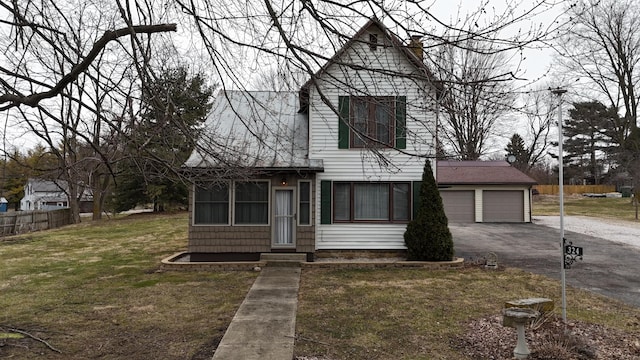 view of front of property with a garage, a front lawn, driveway, and fence