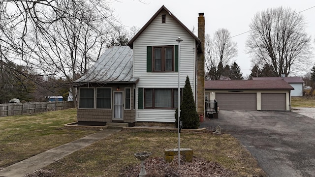 view of front of house with a front yard, fence, a chimney, entry steps, and a garage