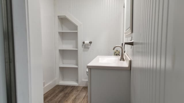 bathroom featuring toilet, wood finished floors, and vanity