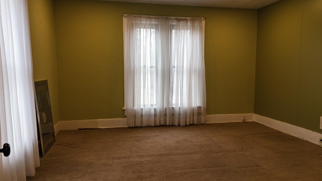 spare room featuring baseboards and carpet floors