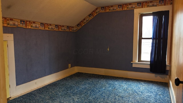 spare room with carpet flooring, a healthy amount of sunlight, baseboards, and lofted ceiling