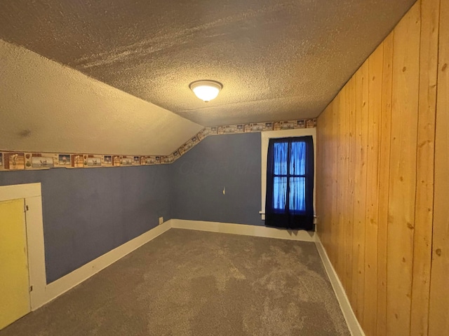 324 E Main St, Cardington, OH 43315 - additional living space featuring a textured ceiling, carpet floors, vaulted ceiling, and wooden walls