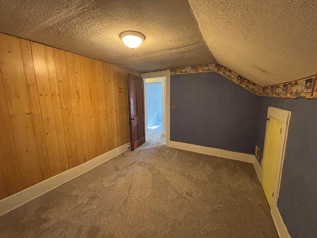 324 E Main St, Cardington, OH 43315 - bonus room with a textured ceiling, carpet floors, wood walls, and vaulted ceiling