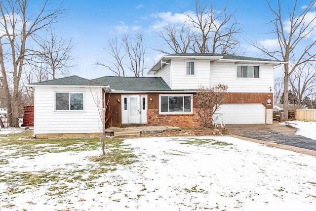 view of front of house with a garage, driveway, and brick siding