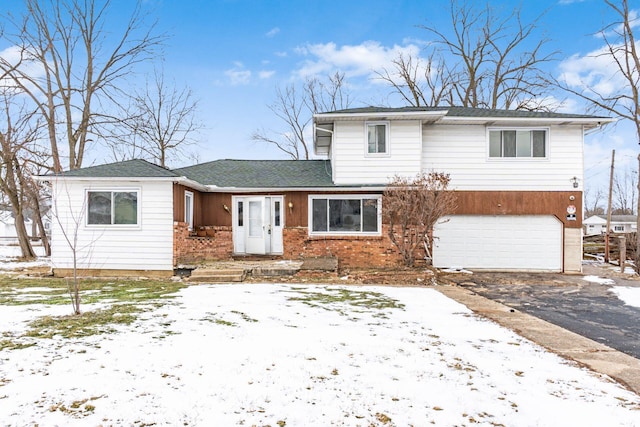 view of front of house with driveway, a garage, and brick siding