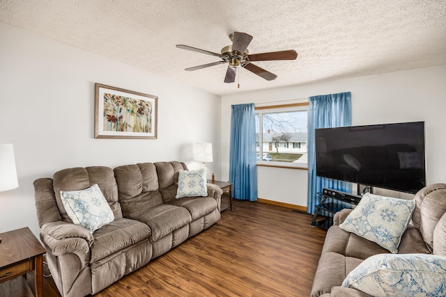 living area featuring a ceiling fan, a textured ceiling, baseboards, and wood finished floors