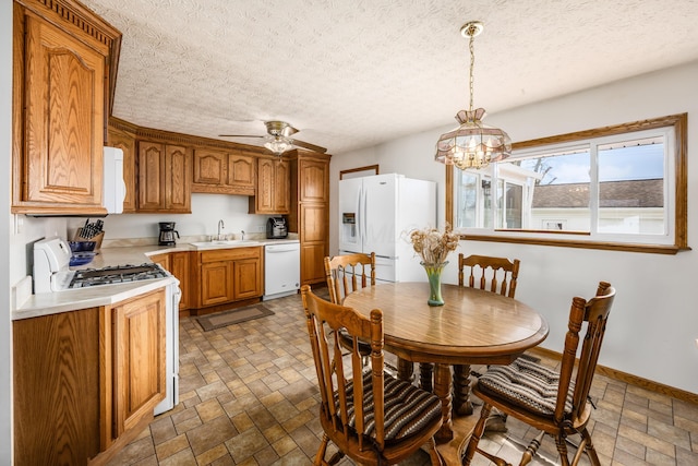 dining area with stone finish floor, a textured ceiling, baseboards, and a ceiling fan