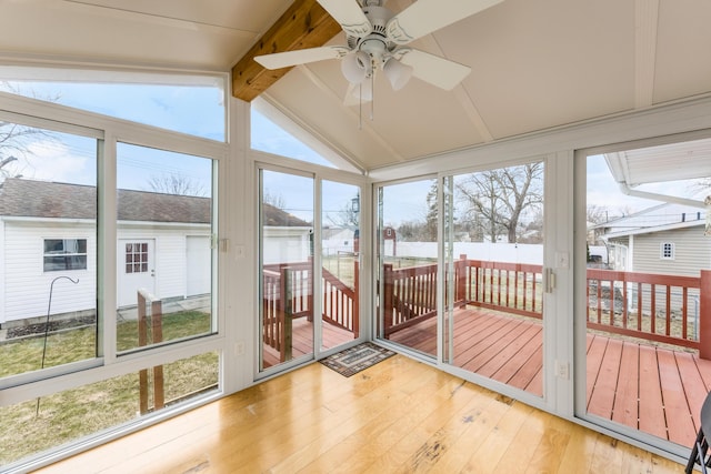 sunroom featuring vaulted ceiling with beams, ceiling fan, and a healthy amount of sunlight