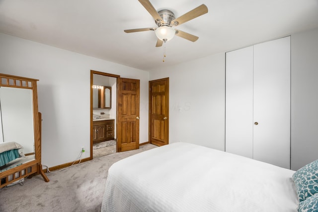 bedroom featuring ceiling fan, connected bathroom, light colored carpet, baseboards, and a closet