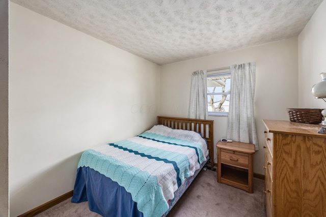 carpeted bedroom with baseboards and a textured ceiling