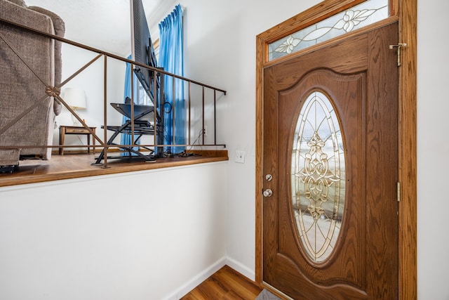 foyer entrance featuring baseboards and wood finished floors