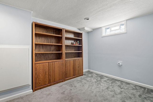 interior space with carpet floors, baseboards, and a textured ceiling