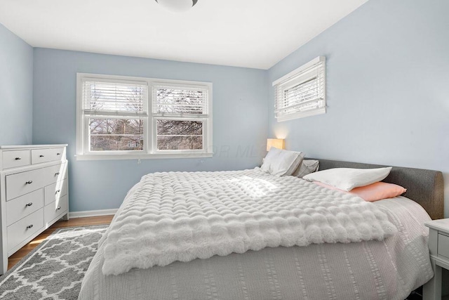 bedroom featuring baseboards and wood finished floors