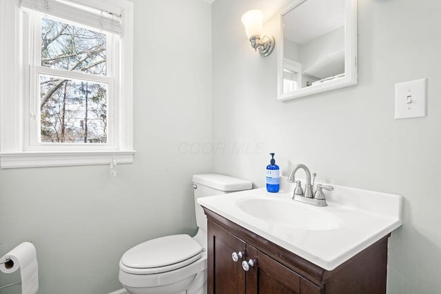 half bath featuring vanity and toilet