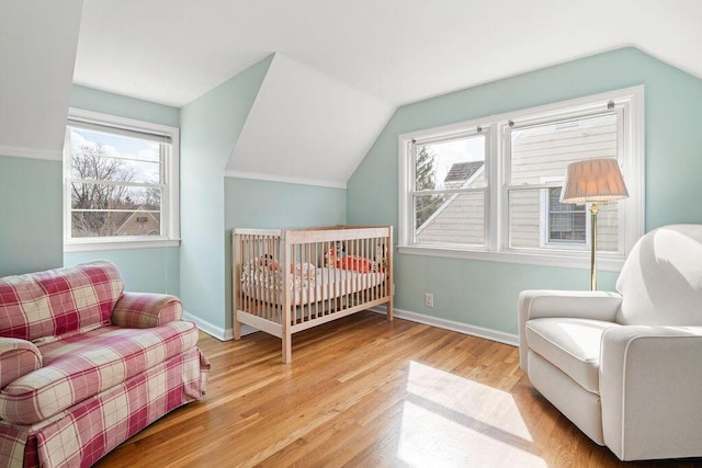 bedroom with lofted ceiling, wood finished floors, and baseboards