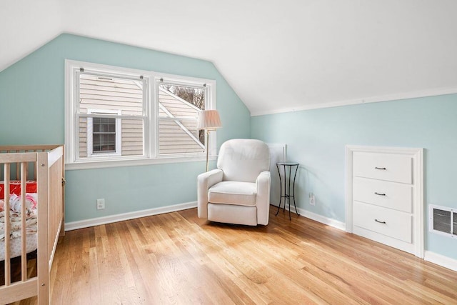 bedroom featuring vaulted ceiling, wood finished floors, visible vents, and baseboards