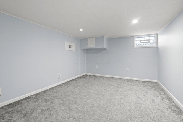 below grade area featuring carpet floors, recessed lighting, visible vents, and baseboards