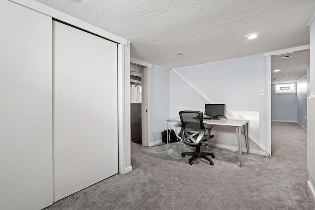 home office featuring carpet, baseboards, and a textured ceiling