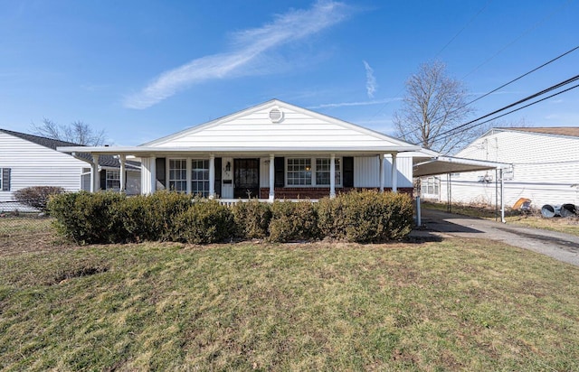 view of front of house featuring a porch, a front yard, fence, a carport, and driveway