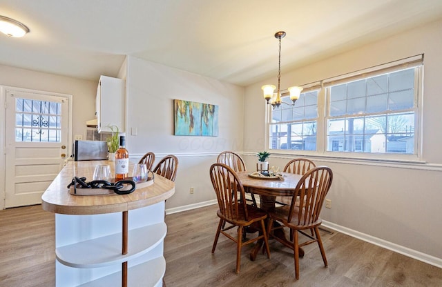 dining room with a wealth of natural light, baseboards, and wood finished floors