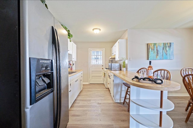 kitchen with white cabinets, light countertops, stainless steel refrigerator with ice dispenser, and light wood finished floors