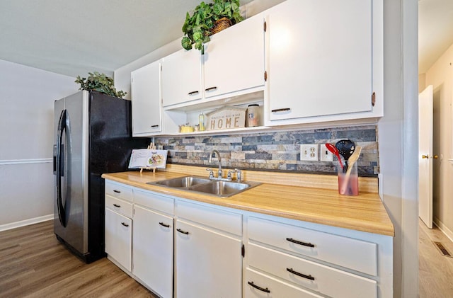 kitchen featuring white cabinets, a sink, and light wood finished floors