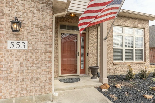 view of exterior entry with brick siding