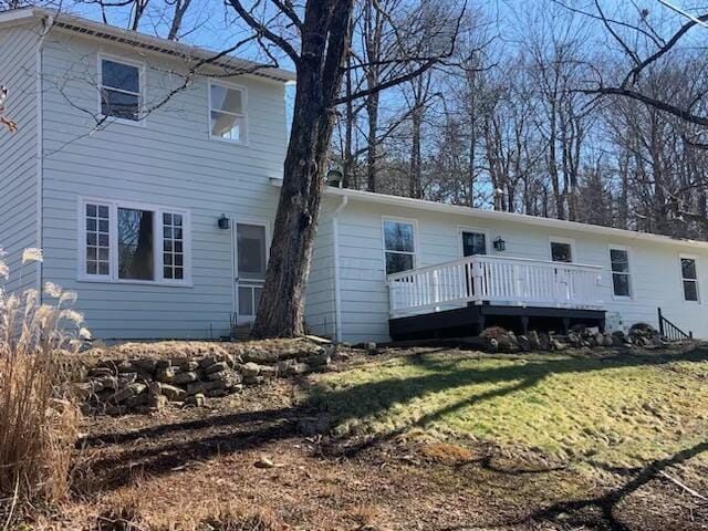 back of property featuring a deck and a yard