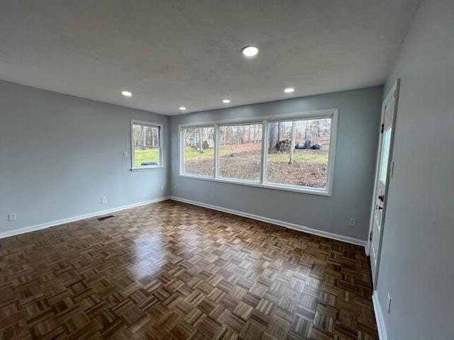 spare room with recessed lighting, visible vents, and baseboards