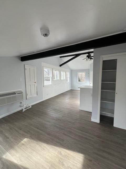 unfurnished living room with lofted ceiling with beams, dark wood finished floors, and a ceiling fan