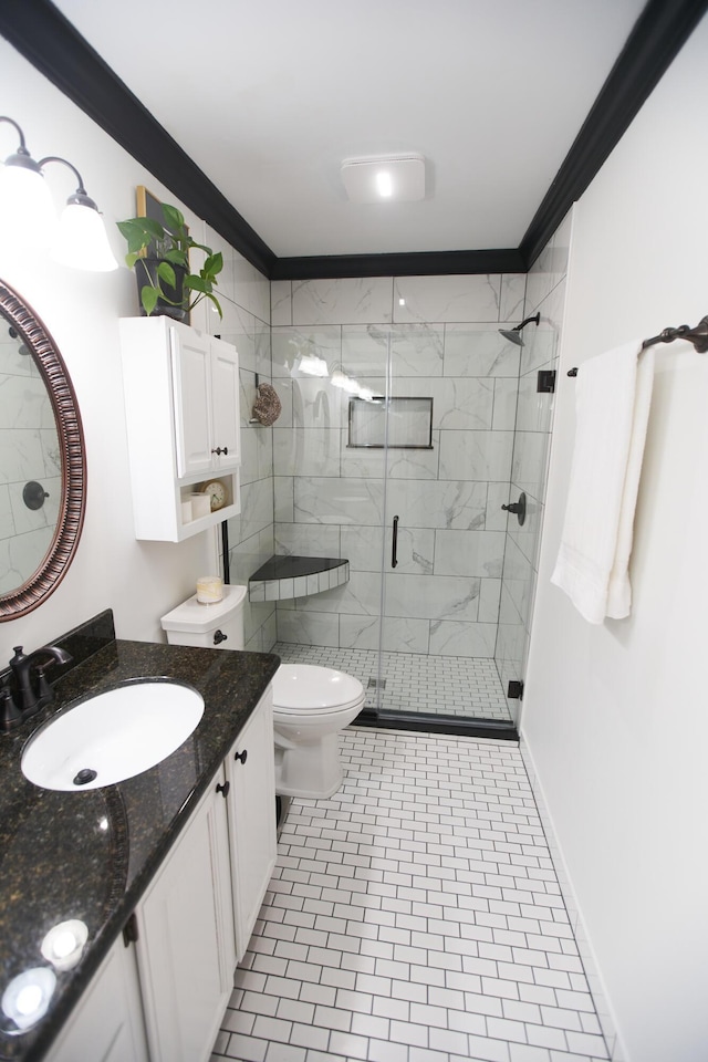 full bathroom featuring toilet, vanity, baseboards, a stall shower, and crown molding