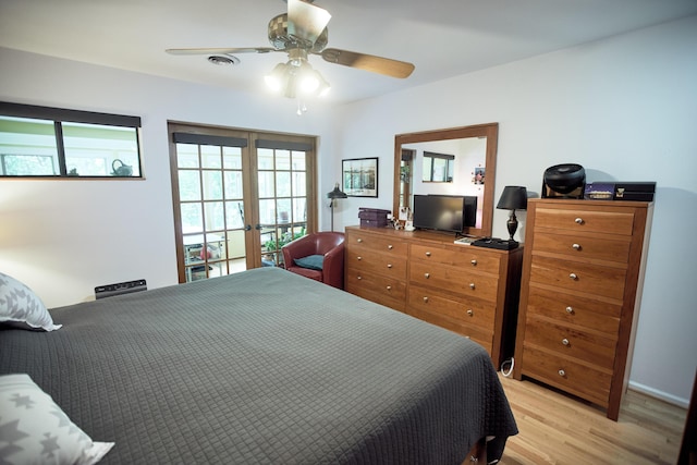 bedroom featuring light wood-style flooring, multiple windows, a ceiling fan, and french doors