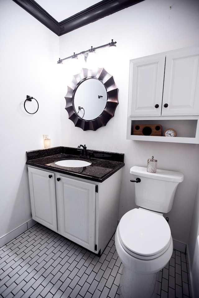 bathroom featuring baseboards, vanity, toilet, and tile patterned floors