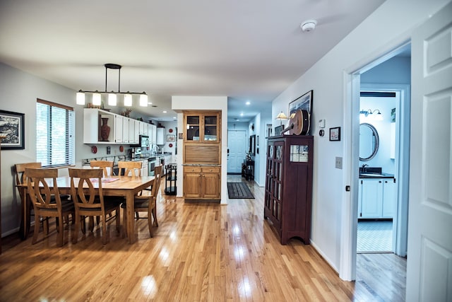 dining space with light wood-type flooring and baseboards