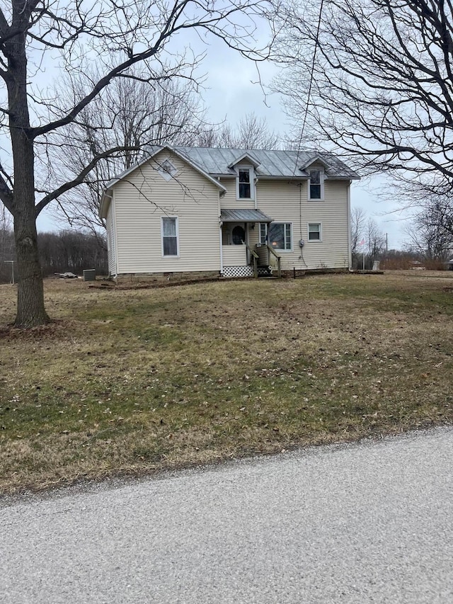 view of front facade with a front yard, a standing seam roof, and metal roof