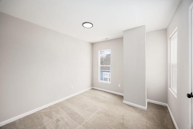 spare room with carpet, visible vents, and baseboards