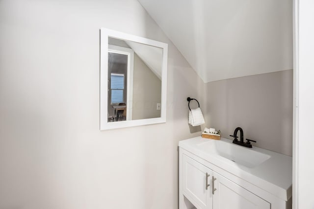 bathroom with lofted ceiling and vanity