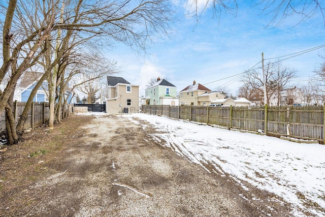 yard layered in snow with a residential view and a fenced backyard