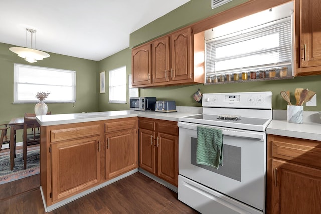 kitchen with white electric stove, light countertops, stainless steel microwave, and a peninsula