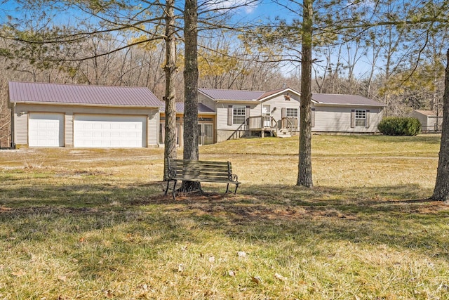 view of front of home featuring an outbuilding, metal roof, and a front yard