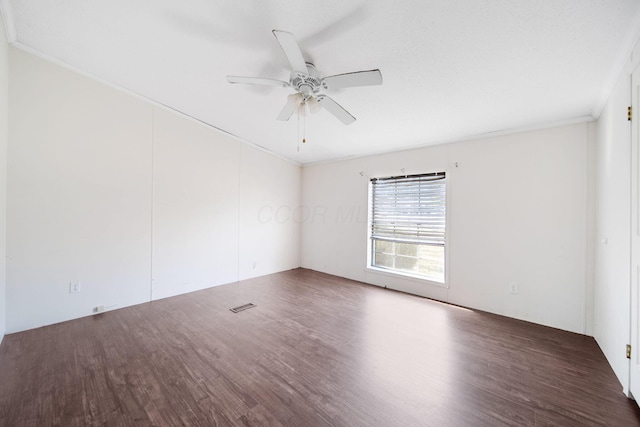 spare room featuring a ceiling fan, visible vents, wood finished floors, and ornamental molding