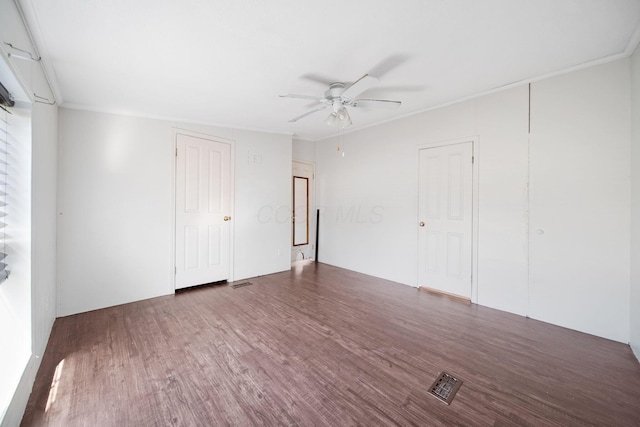 spare room featuring visible vents, ceiling fan, and wood finished floors