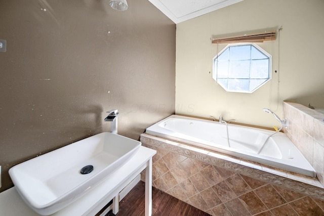 full bath featuring tiled bath and crown molding