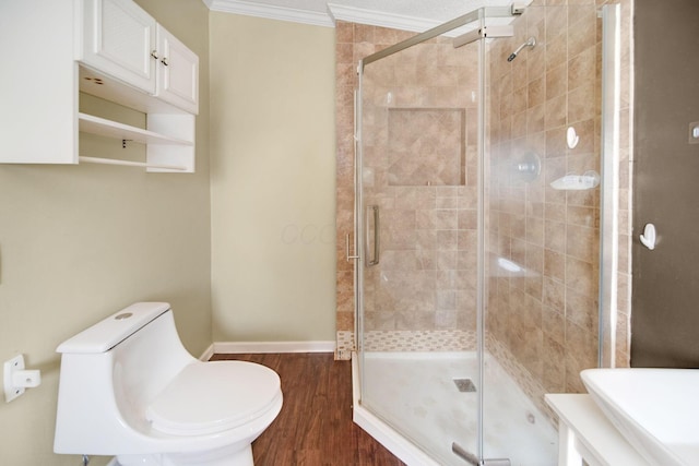 bathroom featuring a shower stall, toilet, and crown molding