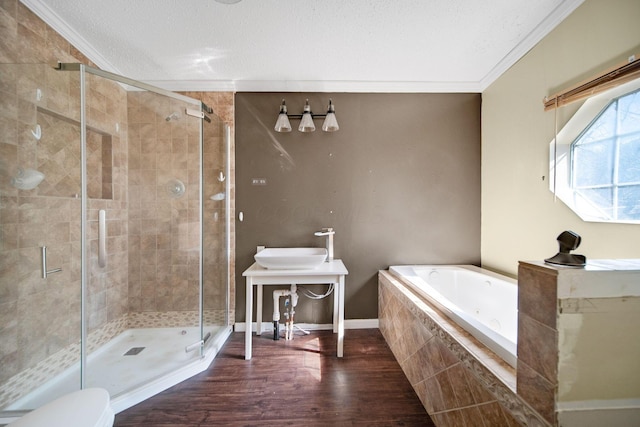 full bathroom featuring wood finished floors, a textured ceiling, crown molding, a shower stall, and a bath