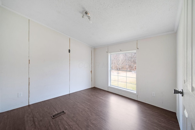 unfurnished bedroom featuring a textured ceiling, wood finished floors, and visible vents